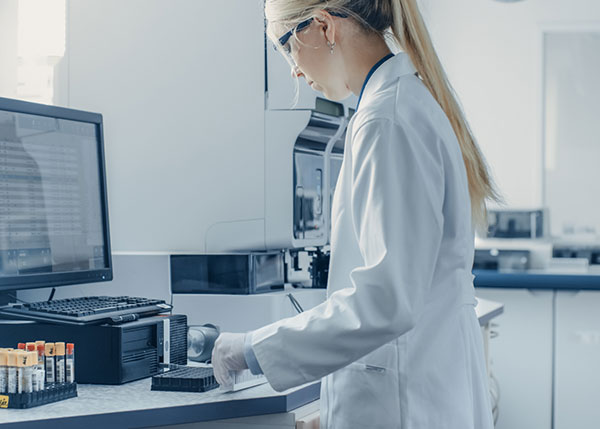 Woman in lab coat working on computer