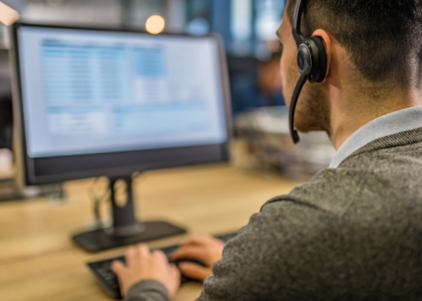 Man at computer with headset. Looks like a call center worker. 