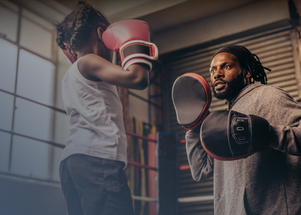 Child and man boxing and training